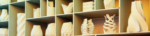 Collection de vases design en céramique blanche exposés sur des étagères en bois, décoration moderne et artistique.